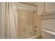 Cozy bathroom featuring a tub, shower, tile surround, and updated lighting fixture at 602 N May -- # 17, Mesa, AZ 85201