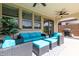 Covered outdoor patio with ceiling fan, dark wicker furniture, and turf backyard at 6931 W Spur Dr, Peoria, AZ 85383
