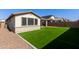 Expansive turf backyard and desert landscaping, complete with a covered patio and barbecue at 6931 W Spur Dr, Peoria, AZ 85383