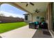Covered outdoor patio with ceiling fans, dark wicker furniture, and low-maintenance artificial turf at 6931 W Spur Dr, Peoria, AZ 85383