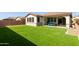 Spacious backyard with artificial turf, desert landscaping, and a covered patio for outdoor living at 6931 W Spur Dr, Peoria, AZ 85383