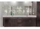 Bathroom featuring double sinks with cabinets, tile floor, and a large mirror at 6931 W Spur Dr, Peoria, AZ 85383