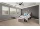 Cozy bedroom featuring a large bed with decorative pillows, soft carpet, and bright windows at 6931 W Spur Dr, Peoria, AZ 85383