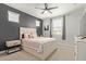 Bright bedroom featuring a ceiling fan, neutral carpet, gray accent wall, and white trim at 6931 W Spur Dr, Peoria, AZ 85383