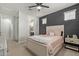 Neutral bedroom with ensuite bathroom, ceiling fan, carpet, and a gray accent wall at 6931 W Spur Dr, Peoria, AZ 85383