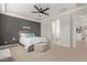 Comfortable bedroom featuring soft carpet, a stylish ceiling fan and gray accent wall at 6931 W Spur Dr, Peoria, AZ 85383