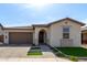 Charming single-story home featuring a well-manicured lawn, tile roof, and attached two-car garage at 6931 W Spur Dr, Peoria, AZ 85383