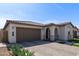 Beautiful single-story home showcasing desert landscaping, a tile roof, and an attached two-car garage at 6931 W Spur Dr, Peoria, AZ 85383