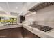 Elegant kitchen with marble counters, dark wood cabinets, and stainless steel cooktop at 7137 E Rancho Vista Dr # 4011, Scottsdale, AZ 85251