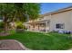 Spacious backyard with a patio, lawn, mature tree, and an outdoor dining set, ideal for enjoying outdoor living at 736 S Winthrop Cir, Mesa, AZ 85204