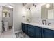 Bathroom showcasing dual sinks with dark blue cabinetry and neutral countertops at 736 S Winthrop Cir, Mesa, AZ 85204