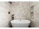 Modern bathroom with a freestanding soaking tub, black fixtures, and white tile at 736 S Winthrop Cir, Mesa, AZ 85204