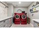 Laundry room featuring red washer/dryer, cabinets, white tile, and shelves at 736 S Winthrop Cir, Mesa, AZ 85204