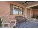 Cozy front porch features brick accents, comfortable seating, and a welcoming atmosphere for relaxing outdoors at 736 S Winthrop Cir, Mesa, AZ 85204