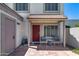 Charming front entrance with covered patio, seating area, and a decorative red door at 7808 E Valley Vista Dr, Scottsdale, AZ 85250