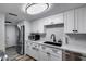 Well-lit kitchen featuring stainless steel appliances, modern white cabinets, and a sleek black sink at 7808 E Valley Vista Dr, Scottsdale, AZ 85250