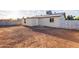 A gravel-covered backyard featuring the back exterior of the home with multiple windows at 8021 W Hazelwood St, Phoenix, AZ 85033
