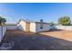 A gravel-covered backyard featuring the back exterior of the home with multiple windows at 8021 W Hazelwood St, Phoenix, AZ 85033