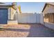Gravel-covered backyard featuring a white wooden gate between two homes at 8021 W Hazelwood St, Phoenix, AZ 85033