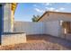 Gravel-covered backyard featuring a white wooden gate and block fence between two homes at 8021 W Hazelwood St, Phoenix, AZ 85033