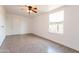 Bright bedroom featuring tile floors, a ceiling fan, and a window to let in natural light at 8021 W Hazelwood St, Phoenix, AZ 85033