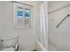 Bright bathroom featuring a bathtub with shower, white tile, and a window at 8318 E Via De Los Libros --, Scottsdale, AZ 85258