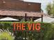 Exterior of The Vig with sign surrounded by lush greenery and outdoor seating at 8318 E Via De Los Libros --, Scottsdale, AZ 85258