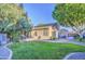 Lush backyard featuring a grassy area, pergola-covered dining space and mature trees for shade at 8748 W Maui Ln, Peoria, AZ 85381