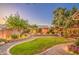 Serene backyard featuring a lush lawn, mature trees, and manicured landscaping at 8748 W Maui Ln, Peoria, AZ 85381