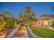 Beautiful backyard showcasing mature trees, landscape lighting, and a covered patio area at 8748 W Maui Ln, Peoria, AZ 85381