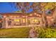 Inviting backyard with a covered patio, lush lawn, and ambient string lighting at 8748 W Maui Ln, Peoria, AZ 85381