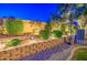 Terraced backyard featuring manicured shrubs, retaining wall, and gravel ground cover at 8748 W Maui Ln, Peoria, AZ 85381