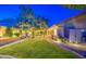 Landscaped backyard featuring manicured lawn, shrubs, and ample space for outdoor entertainment at 8748 W Maui Ln, Peoria, AZ 85381