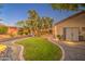 Tranquil backyard oasis with a manicured lawn, stone pathways, and outdoor lighting at 8748 W Maui Ln, Peoria, AZ 85381