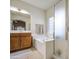 Bright bathroom has single sink, soaking tub, glass-enclosed shower and tile floors at 8748 W Maui Ln, Peoria, AZ 85381