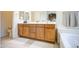 Bright bathroom has dual sinks, soaking tub, and tile floors at 8748 W Maui Ln, Peoria, AZ 85381