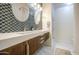 Stylish bathroom featuring a modern floating vanity with dual sinks and decorative patterned wall tiles at 8748 W Maui Ln, Peoria, AZ 85381