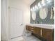 Contemporary bathroom featuring dual vanity with designer mirrors and lights, complemented by patterned tiling at 8748 W Maui Ln, Peoria, AZ 85381
