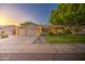 A charming single-story home with a three-car garage, large tree, and manicured lawn at 8748 W Maui Ln, Peoria, AZ 85381