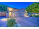 Single-Gathering home featuring a well-lit three-car garage and manicured landscaping at 8748 W Maui Ln, Peoria, AZ 85381