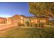 Attractive single-story home with a lush green lawn, desert landscaping, and a convenient three-car garage at 8748 W Maui Ln, Peoria, AZ 85381