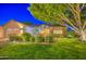 Charming home featuring lush green grass, mature landscaping, and a spacious two-car garage at 8748 W Maui Ln, Peoria, AZ 85381