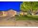 Charming home with spacious three-car garage, rock landscaping, and a lush, green lawn at 8748 W Maui Ln, Peoria, AZ 85381