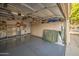 Spacious garage featuring epoxy flooring, overhead storage racks, custom cabinets, and work sink at 8748 W Maui Ln, Peoria, AZ 85381