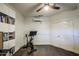 Home office features exercise equipment, storage shelves, and wood floors at 8748 W Maui Ln, Peoria, AZ 85381