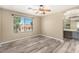 Spacious bedroom with wood-look floors, large windows, and an en-suite bathroom at 8795 W Windsor Dr, Peoria, AZ 85381
