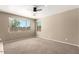 Serene bedroom with neutral carpet, dual windows offering natural light, and a minimalist aesthetic at 8795 W Windsor Dr, Peoria, AZ 85381