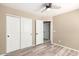 Bedroom with closet and a doorway, featuring a ceiling fan and wood-look floors at 8795 W Windsor Dr, Peoria, AZ 85381