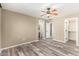 Generously sized bedroom with wood-look floors, ceiling fan, and multiple doorways at 8795 W Windsor Dr, Peoria, AZ 85381