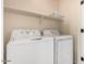 Laundry room featuring a white washer and dryer with shelving above at 8795 W Windsor Dr, Peoria, AZ 85381